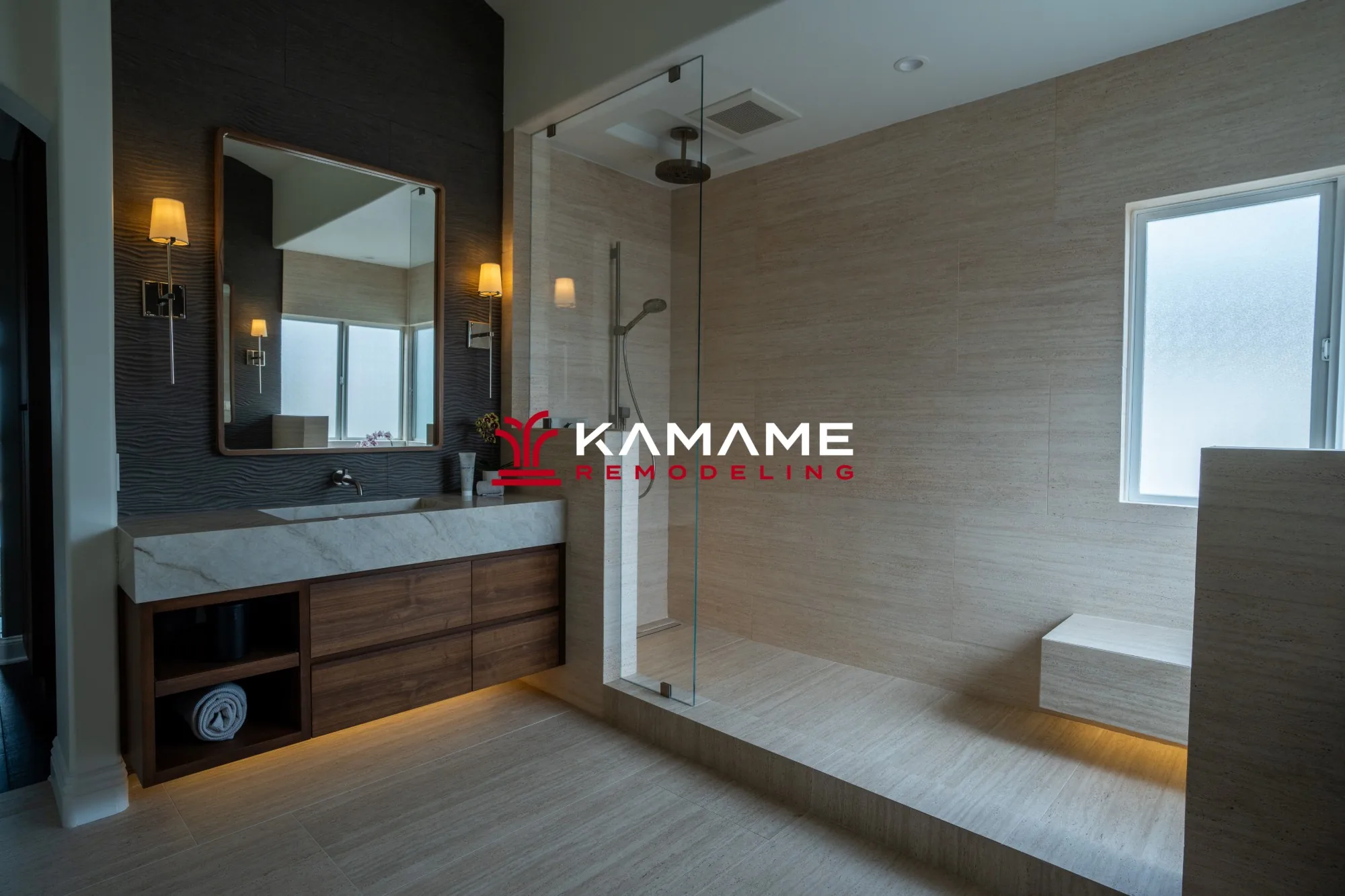 Bathroom remodel with a stone vanity, wall sconces, and a tiled walk-in shower